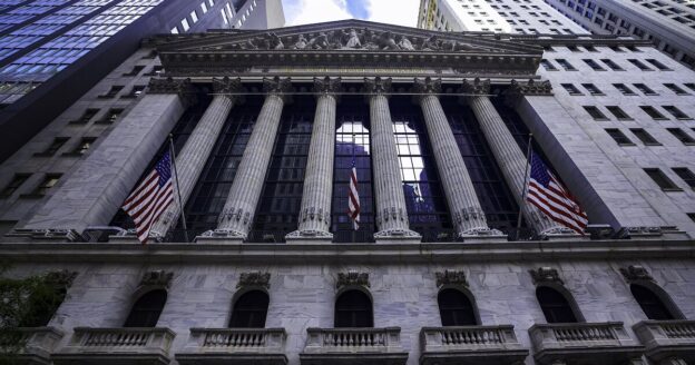 The New York Stock Exchange with American flags; the stock market is open on Columbus Day