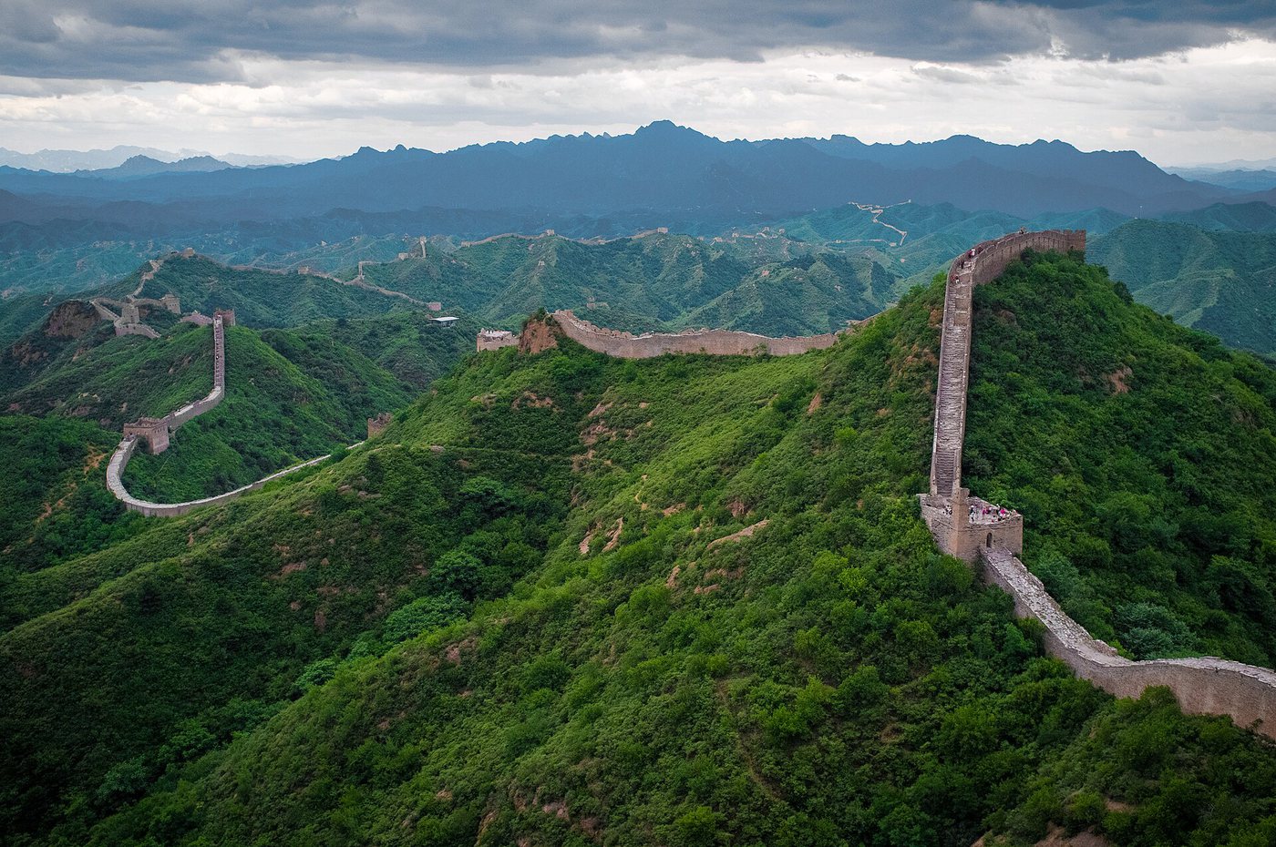 The Great Wall of China winding over green mountain ridges at Jinshanling