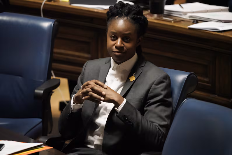 A member seated in the Manitoba Legislative Assembly chamber